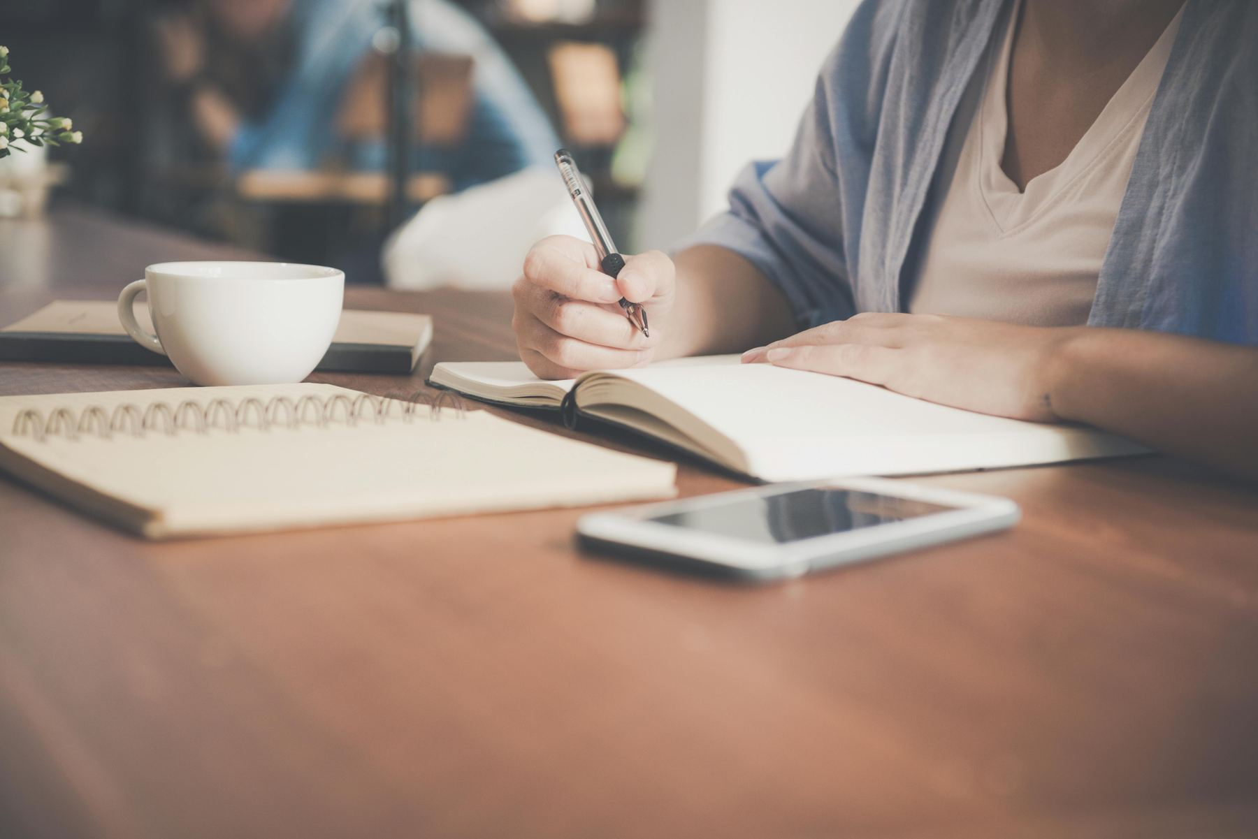 Prise de notes lors d'un bilan, tasse de café à côté